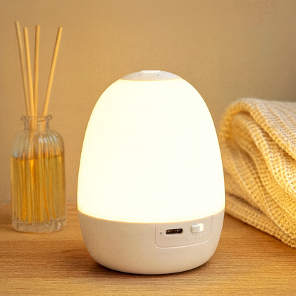 Lampe d’ambiance LED blanche posée sur une table en bois, diffusant une lumière chaude et apaisante, idéale pour une atmosphère zen